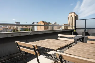 a table and chairs on a roof with a view of a city at GuestReady – Urban comfort in Vila Nova de Gaia in Vila Nova de Gaia