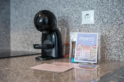 a hair drier on a counter next to a book at GuestReady – Urban comfort in Vila Nova de Gaia in Vila Nova de Gaia