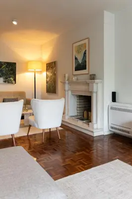 a living room with two white chairs and a fireplace at Porto Pátio by MP in Porto