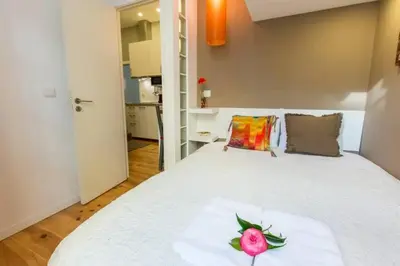 a bedroom with a white bed with a flower on it at Downtown Porto Twins II - City Center in Porto