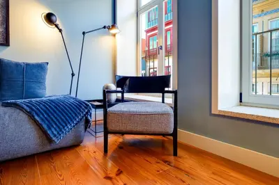 a living room with a chair and a window at Porto Heritage Balcony Apartment in Porto