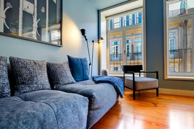 a living room with a couch and two windows at Porto Heritage Balcony Apartment in Porto