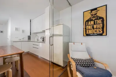 a kitchen with a glass refrigerator and a table at An apartment with a view - Nó's place in Vila Nova de Gaia
