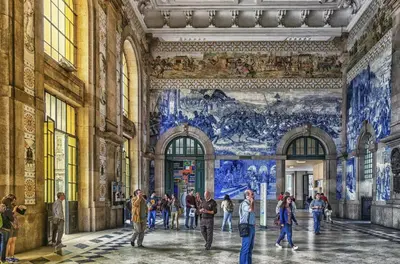 people walking in a hallway in a building with a mural at Studios Baixa Downtown Porto in Porto