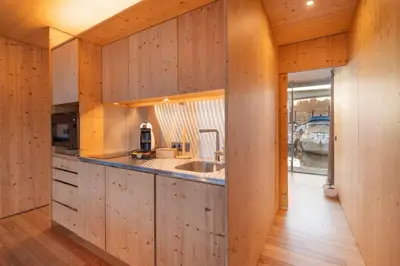 a kitchen with wooden walls and a counter with a sink at SLEEPBOAT- Modern Houseboat in Porto in Bicas