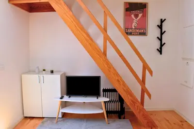 a room with a desk with a computer and a staircase at O Refúgio das Caves by Horizon View Madeira in Vila Nova de Gaia