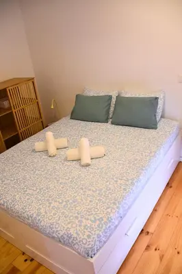 a bed with two pillows on it in a room at O Refúgio das Caves by Horizon View Madeira in Vila Nova de Gaia