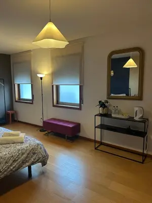 a living room with a bed and a mirror at Burnay Porto Suites in Porto