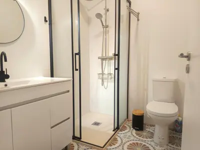 a bathroom with a shower and a toilet and a sink at Charming Campanhã Family Home in Porto