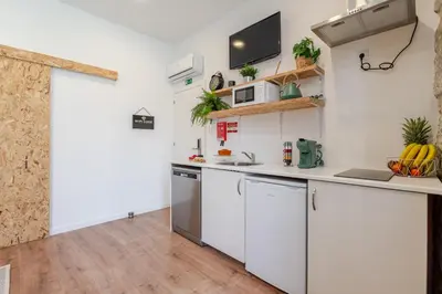 a kitchen with white cabinets and a counter top at DesKanzo Guest House - Raúl Doria in Porto