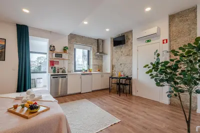 a kitchen and living room with a table in a room at DesKanzo Guest House - Raúl Doria in Porto