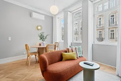 a living room with a orange chair and a table at GuestReady - Music Scale Studios in Porto