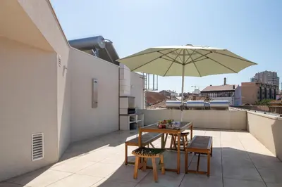 a patio with a table and an umbrella on a roof at Morro Flat w Terrace by LovelyStay in Vila Nova de Gaia