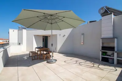 a patio with a table and an umbrella on a roof at Morro Flat w Terrace by LovelyStay in Vila Nova de Gaia