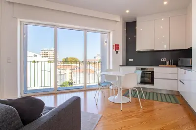 a kitchen and living room with a table and chairs at Morro Flat w Terrace by LovelyStay in Vila Nova de Gaia