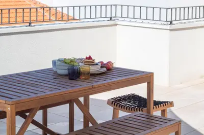 a wooden table with a bowl of food on a balcony at Morro Flat w Terrace by LovelyStay in Vila Nova de Gaia