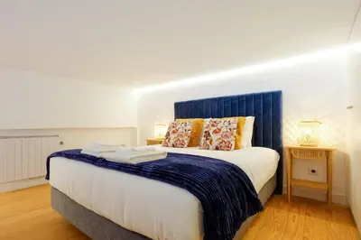 a bedroom with a large bed with a blue headboard at Duque Luxury in Porto