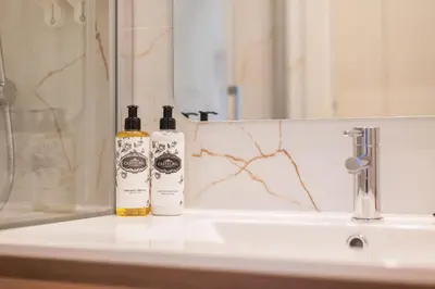 two bottles of alcohol sitting on a bathroom sink at Luxury Style 20 with AC Downtown Porto near Metro in Porto