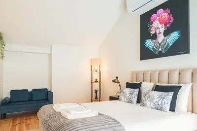 a bedroom with a bed and a blue chair at Luxury Style 30 with AC Downtown Porto near Metro in Porto