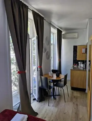 a room with a table and chairs and a kitchen at Gray Red Porto Apart in Porto