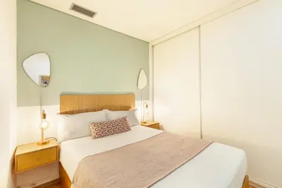 a bedroom with a large white bed and two mirrors at D&S - Porto Theater Apartment in Porto