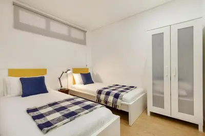 a bedroom with two beds and a cabinet at D&S - Porto Theater Apartment in Porto