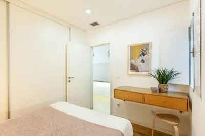 a bedroom with a bed and a desk with a plant on it at D&S - Porto Theater Apartment in Porto