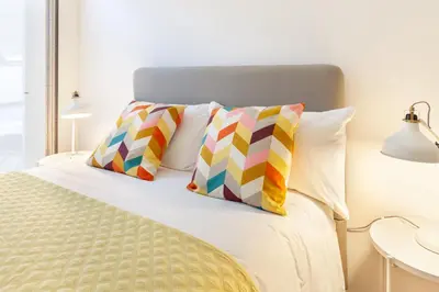 a bedroom with a bed with two colorful pillows at D&S - Porto Theater Apartment in Porto