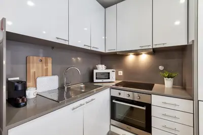 a kitchen with white cabinets and a sink and a microwave at D&S - Porto Theater Apartment in Porto