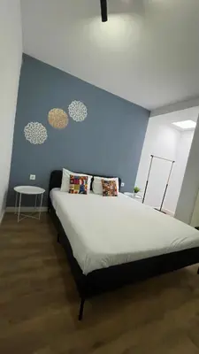 a bedroom with a large bed with a blue wall at Porto Bonfim suites in Porto
