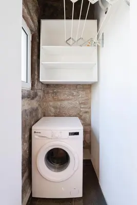 a laundry room with a washer and dryer at Cozy Studio with Workspace by HostWise in Porto