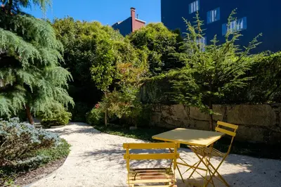 a table and two chairs sitting in a garden at Quinta dos Cedros Garden & Terrace in Porto