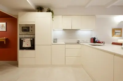 a white kitchen with white cabinets and appliances at Quinta dos Cedros Garden & Terrace in Porto