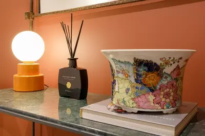 a vase sitting on top of a book next to a lamp at Quinta dos Cedros Garden & Terrace in Porto