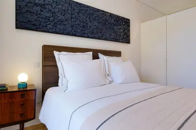 a bedroom with a bed with white pillows at Quinta dos Cedros Garden & Terrace in Porto