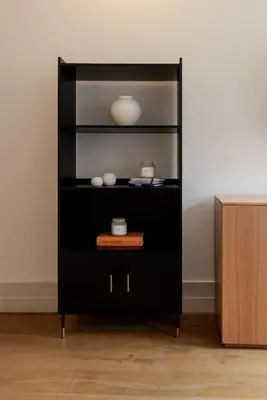 a black book shelf with a white vase on it at Central & Cozy Studio by HostWise in Vila Nova de Gaia