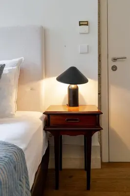 a lamp on a table next to a bed at Central & Cozy Studio by HostWise in Vila Nova de Gaia