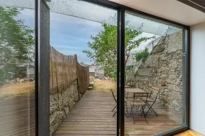 a glass extension to a house with a stone wall at GuestReady - Peaceful retreat in Porto in Porto