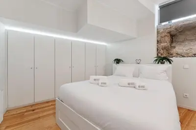 a white bedroom with a large white bed at GuestReady - Peaceful retreat in Porto in Porto
