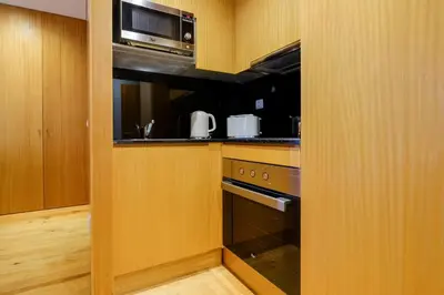 a kitchen with a stove and a microwave at Trindade Essence Duo Suites in Porto