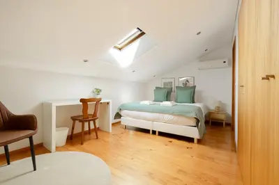 a white bedroom with a bed and a desk at Trindade Essence Duo Suites in Porto