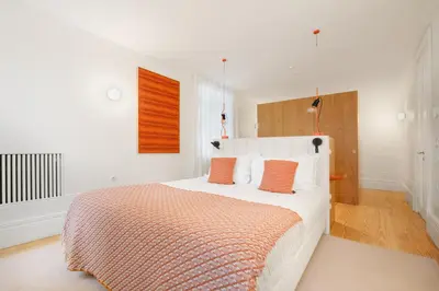 a bedroom with a large white bed with orange pillows at City Retreat by Reframe stay in Porto in Porto