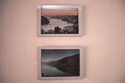 two pictures hanging on a wall with a tv at Modern and quiet T1 with private Garage in Porto