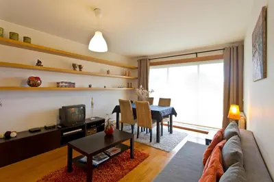 a living room with a couch and a table at Modern and quiet T1 with private Garage in Porto