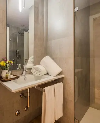 a bedroom with a white bed and a stone wall at Porto River in Porto