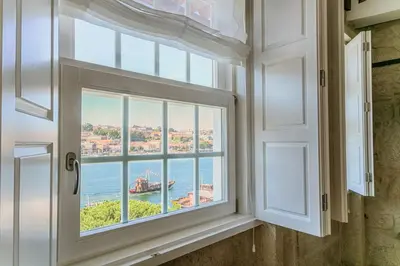 a bedroom with a bed and a kitchen at Porto River in Porto