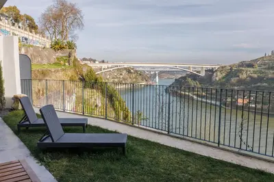 a bridge over a river with boats in the water at Miradouro River Views & Patio by PortoCityHosts in Porto