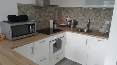 a white kitchen with a microwave and a sink at Sweet apartment in Porto in Porto