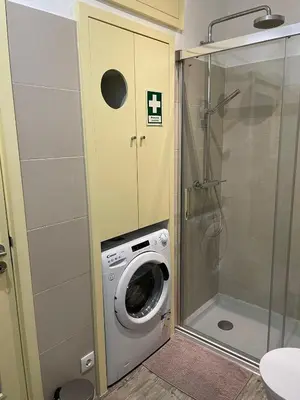 a washing machine in a bathroom with a shower at Sweet apartment in Porto in Porto