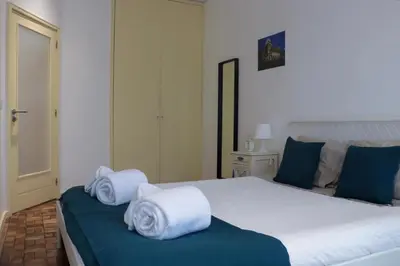 a bedroom with a large bed with towels on it at Sweet apartment in Porto in Porto